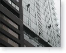professional industrial abseilers polishing windows on highrise hotel