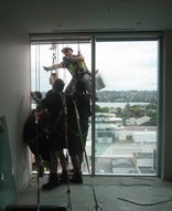 professional industrial abseilers installing glazing on a high rise apartment